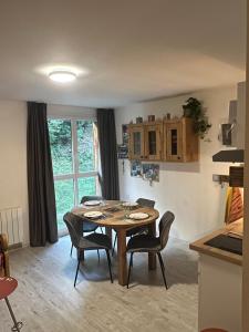 a kitchen with a table and chairs in a room at Studio Croix du berger in La Féclaz