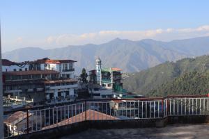 a view of a building with mountains in the background at Hotel Tourist Home By palak Hospitality in Mussoorie +24 photos