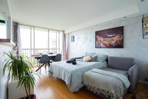 Un dormitorio con una cama, un sofá y una mesa. en 2-pièces ensoleillé, 5 min du metro, en Villejuif
