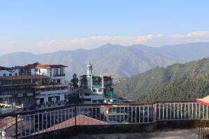 a group of buildings with mountains in the background at Hotel Tourist Home By palak Hospitality in Mussoorie