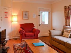 a living room with a couch and a chair at Birch in Llanddona