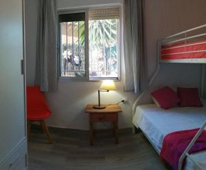 1 dormitorio con 1 cama y 1 mesa con lámpara en La Morada del Yayo 15 minutos de Sevilla, en Las Pajanosas