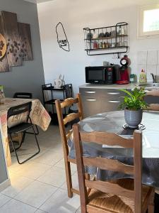 una cucina e una sala da pranzo con tavolo e sedie di L'Arbre de Vy - T2, 42m2, 5 Pers, indépendant, garage, proche Gare a Le Mans