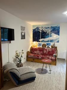 salon z czerwoną kanapą i stołem w obiekcie Studio Croix du berger w mieście La Feclaz