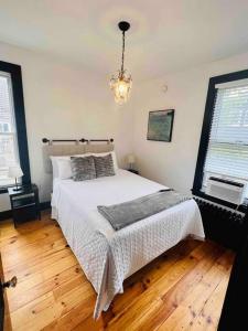 a bedroom with a large bed and a chandelier at Centrally located East End & off-street parking in Portland