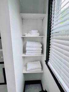 a closet with white towels on shelves and a window at Centrally located East End & off-street parking in Portland