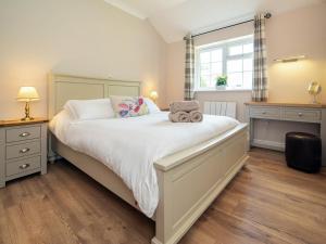 - une chambre avec un lit avec deux animaux rembourrés dans l'établissement 1 Luckington Stables-w8321, à Holcombe