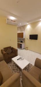 een woonkamer met een bank en een tafel bij درة الراشد للشقق المخدومة in Hafr Al Baten