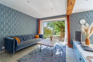 a living room with a blue couch and a table at Cosy Room's in Frontonas