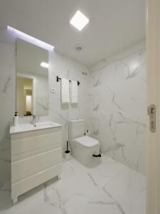 un bagno bianco con un water e un lavandino di Vibrant Host Solutions-Campo 24 Agosto a Porto Altre 37 foto