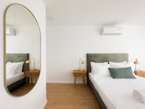 1 dormitorio con espejo y 1 cama en Vibrant Porto Apartments-Campo 24 Agosto en Oporto