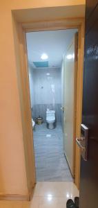 een badkamer met een toilet en een glazen deur bij درة الراشد للشقق المخدومة in Hafr Al Baten