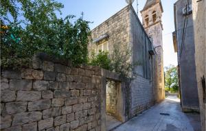 Une allée avec un mur en pierre et une église dans l'établissement Amazing Apartment In Trogir With Kitchen, à Trogir