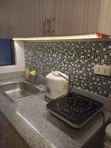 a kitchen counter with a toaster and a sink at Urban Chique Condo in Marilao Bulacan near PhilippineArena in Marilao