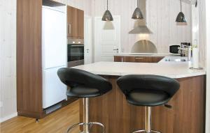 a kitchen with two black bar stools at a counter at Beautiful Home In Hemmet With 4 Bedrooms, Sauna And Wifi in Falen