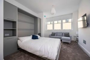 a bedroom with a bed and a couch and a chair at Gainsborough Studio, Sudbury in Sudbury