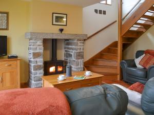a living room with a fireplace and a staircase at Orchard Cottage - Ukc4300 in Littleham