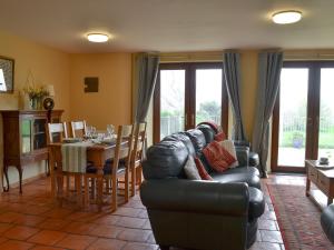 a living room with a leather couch and a table at Orchard Cottage - Ukc4300 in Littleham