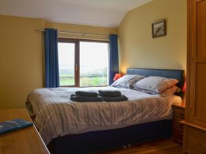 a bedroom with a large bed with a window at Orchard Cottage - Ukc4300 in Littleham