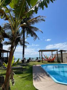 a resort with a swimming pool and a palm tree at Pousada Grandmar, Maragogi in Maragogi
