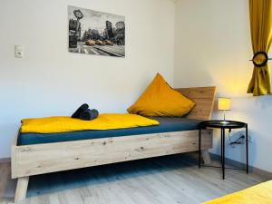 1 dormitorio con cama de madera y almohadas amarillas en Gästehaus Trockau, en Pegnitz