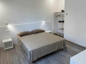 een slaapkamer met een groot bed en 2 tafels bij La Casa di Brando - Bilocale 1 Ancona in Camerano