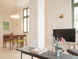 a living room with a tv and a table at OSTKÜSTE - Villa Steigel Design Apartments in Ahlbeck