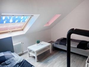 a bedroom with a bed and a table and a window at Comfy Apartment in Krefeld in Krefeld