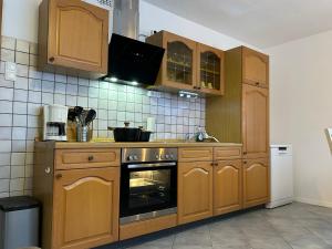 a kitchen with wooden cabinets and an oven at Gästehaus Trockau in Pegnitz