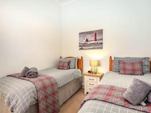 a bedroom with two twin beds and a lighthouse at Admirals Rest in Cromer