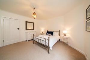 a bedroom with a bed and a dresser and a lamp at The Bensil in Carnoustie