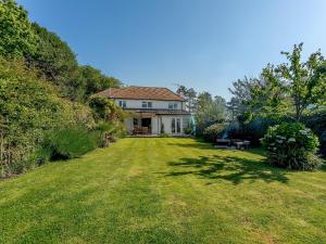 un gran patio con una casa al fondo en Yew Tree House, en Chideock