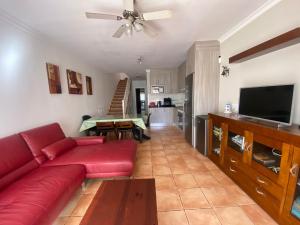 a living room with a red couch and a flat screen tv at 60 El Sultan, 20 Pedroy Guy Vandaele in Corralejo