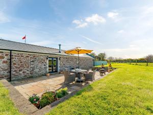 a patio with a table and an umbrella at Puffin Cottage in Peel