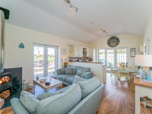 a living room with two blue couches and a fireplace at Puffin Cottage in Peel