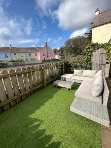 a garden with two couches and a wooden fence at 4 The Quay - Strangford Lough Waterfront in Killyleagh