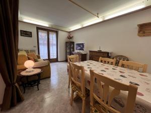 a dining room with a table and a living room at 060 Bilocale, Giustino in Giustino
