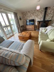 a living room with a couch and a tv at 4 The Quay - Strangford Lough Waterfront in Killyleagh