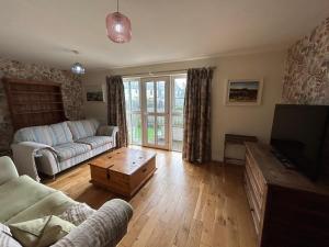 a living room with a couch and a tv at 4 The Quay - Strangford Lough Waterfront in Killyleagh