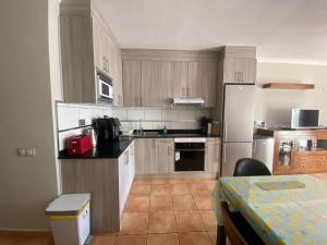 a kitchen with wooden cabinets and a white refrigerator at 60 El Sultan, 20 Pedroy Guy Vandaele in Corralejo