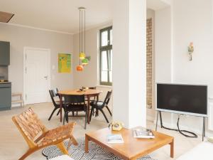 a living room with a table and a tv at OSTKÜSTE - Villa Steigel Design Apartments in Ahlbeck