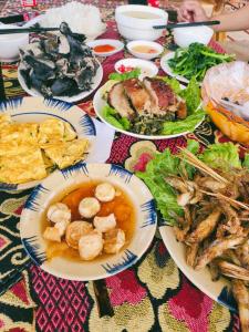 a table with plates of food on a table at Moc's House in Bắc Hà