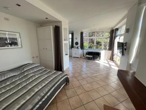 ein Schlafzimmer mit einem Bett und ein Wohnzimmer in der Unterkunft Studio - Villa Cardano in Como