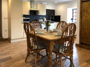 a kitchen with a wooden table and four chairs at The Pig Sty in Barlow