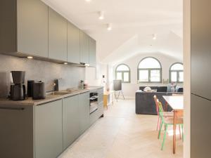 a kitchen with white cabinets and a living room at OSTKÜSTE - Villa Steigel Design Apartments in Ahlbeck