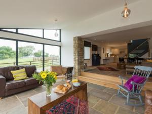 Moorgate Cottage في Kelbrook: غرفة معيشة مع أريكة وطاولة