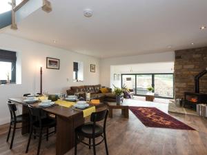 a kitchen and living room with a table and chairs at Moorgate Cottage in Kelbrook