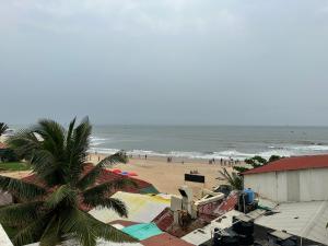 een strand met een palmboom en de oceaan bij Hotel Salty Waves Baga in Baga