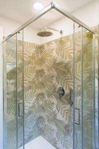 a shower with a glass enclosure with a patterned wall at Garden View Sorrento in Sorrento