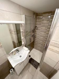 y baño con lavabo blanco y ducha. en The Lovely Loft, en Liubliana
